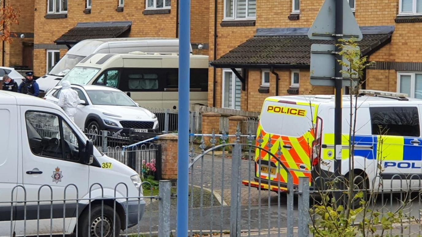 Forensic police van and a generic police van parked in a residential area