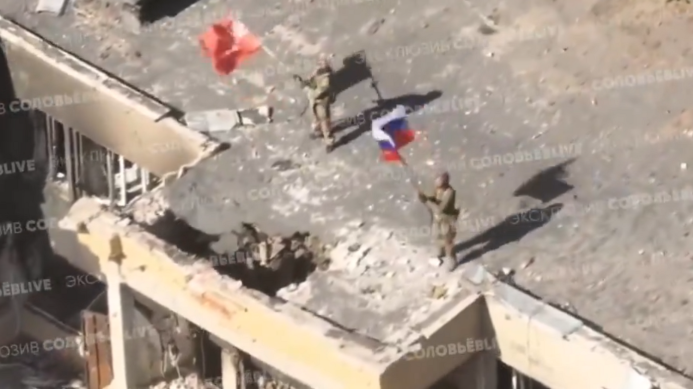 Pro-Kremlin military bloggers have posted images showing Russian flags flying over ruined buildings