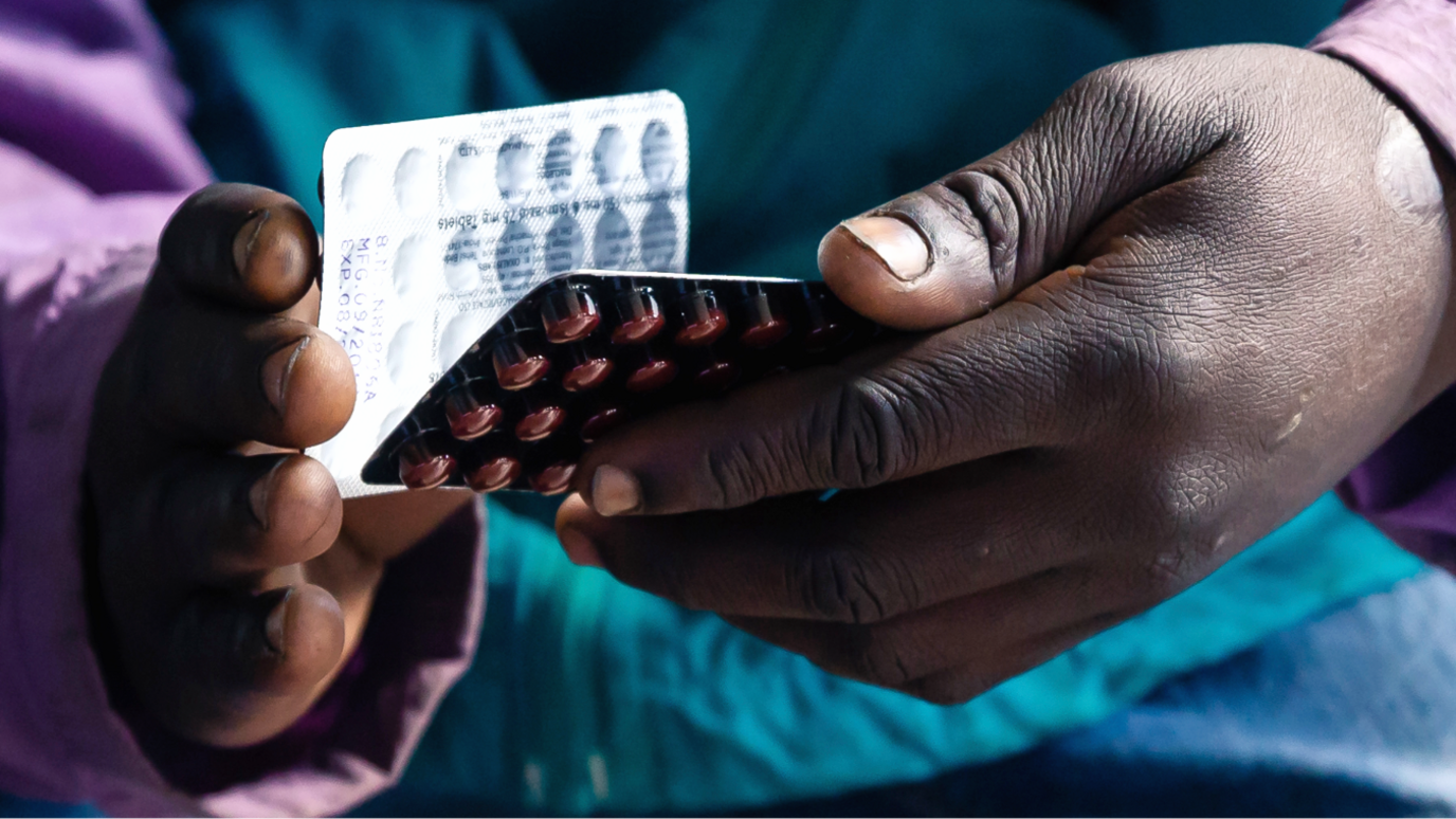 The hand of an HIV positive patient in Zimbabwe holding a packet of tablets received as part of his treatment in Harare - June 2019.