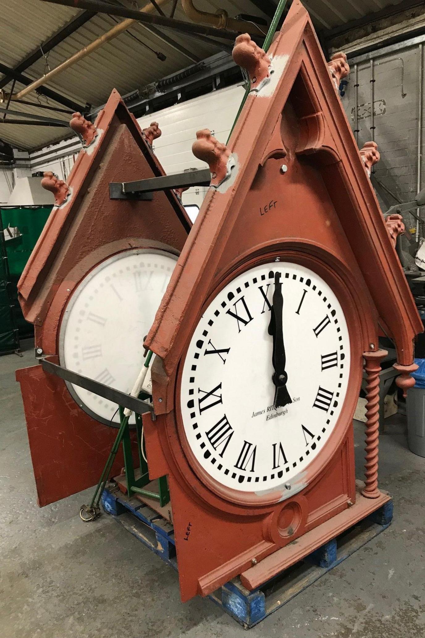 The clock has a white face and black hands. It is in a brown casing with a triangular top.
