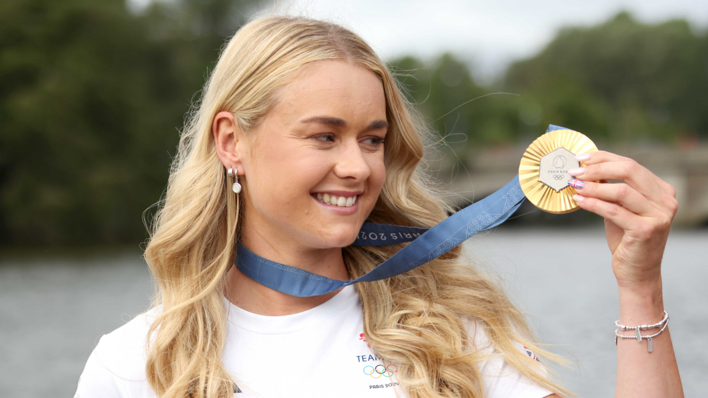 Hannah Scott displaying her Olympic gold medal, with blue ribbon attached