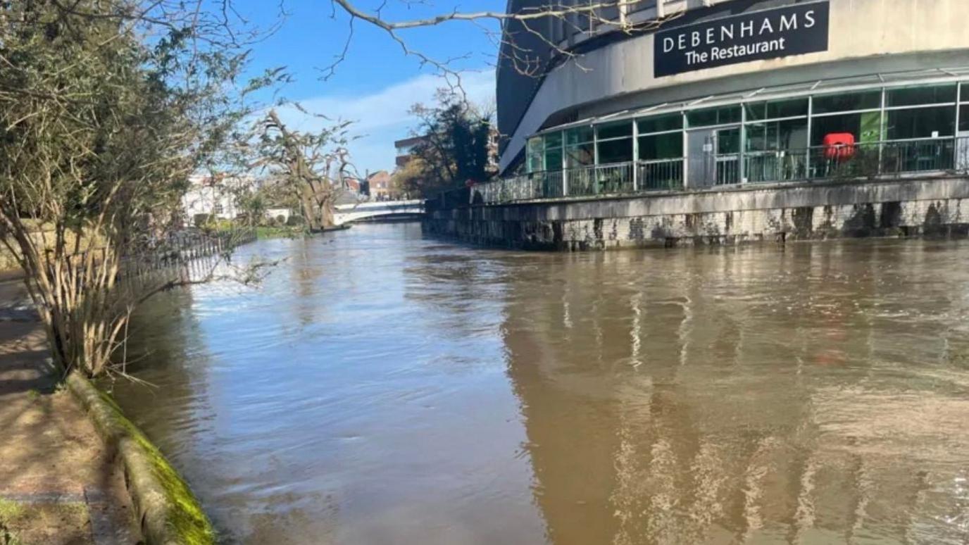 Water surrounds the outside of a Debenhams store.