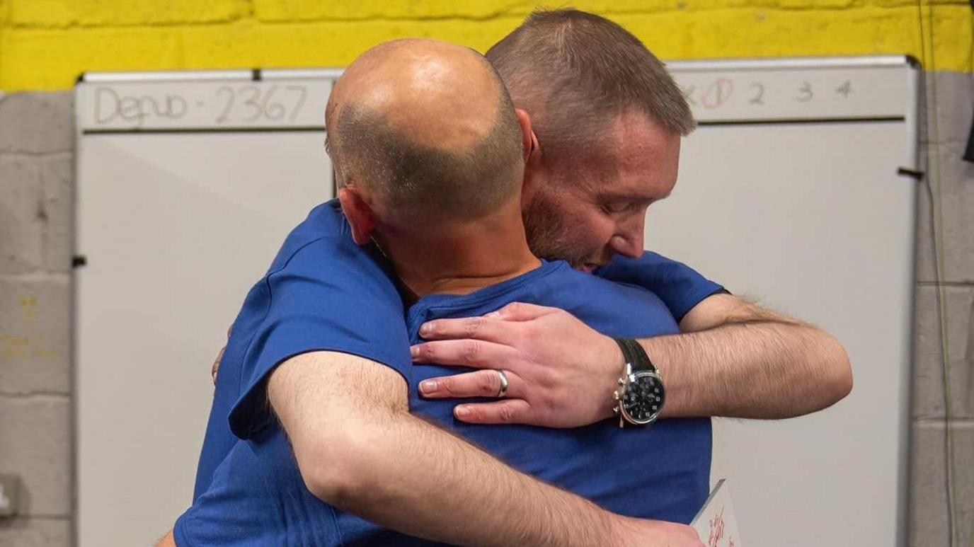 Image of Mark Butcher and David Champion hugging.