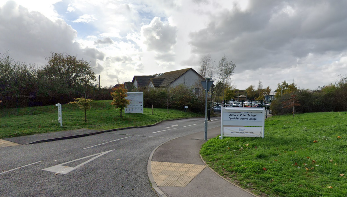 The entrance to the school and two signs outside the school