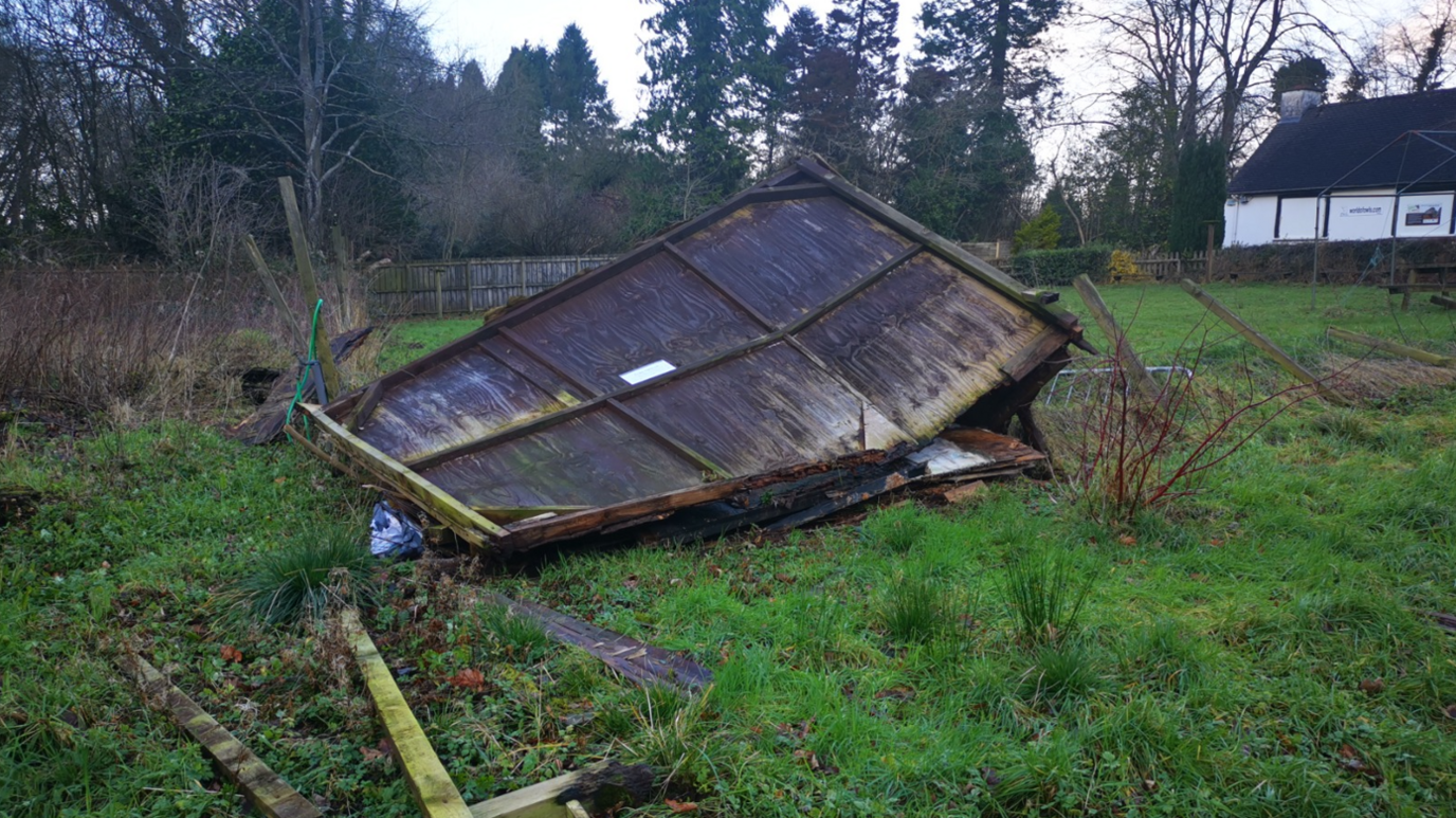 Damaged wood panel fence on the ground in field at World Of Owls in Randalstown, County 