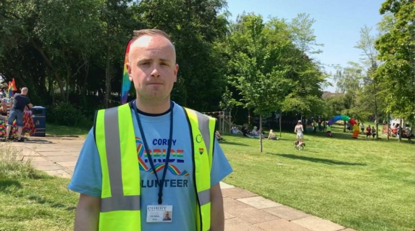 Callum Reilly with very short brown hair wearing yellow hi-viz in a field