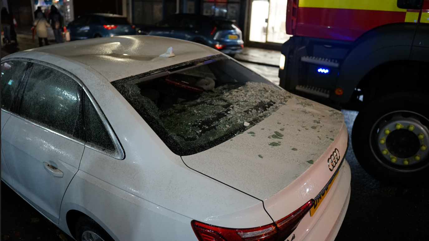 A white audi seen from slightly above with debris and glass on the boot.