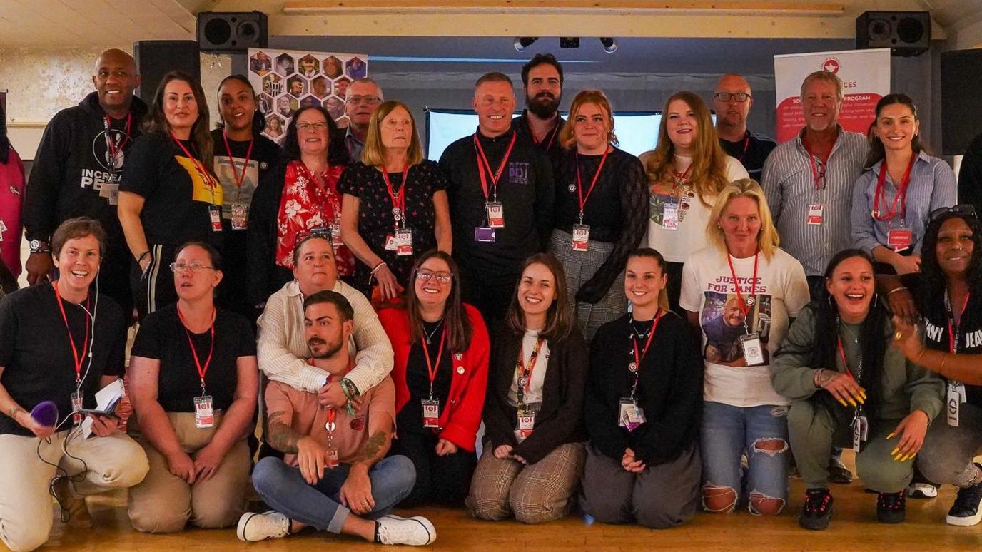 Group photo of the campaigners and services who came to the event some kneeling some standing in the function hall at the Moonrakers pub in Swindon