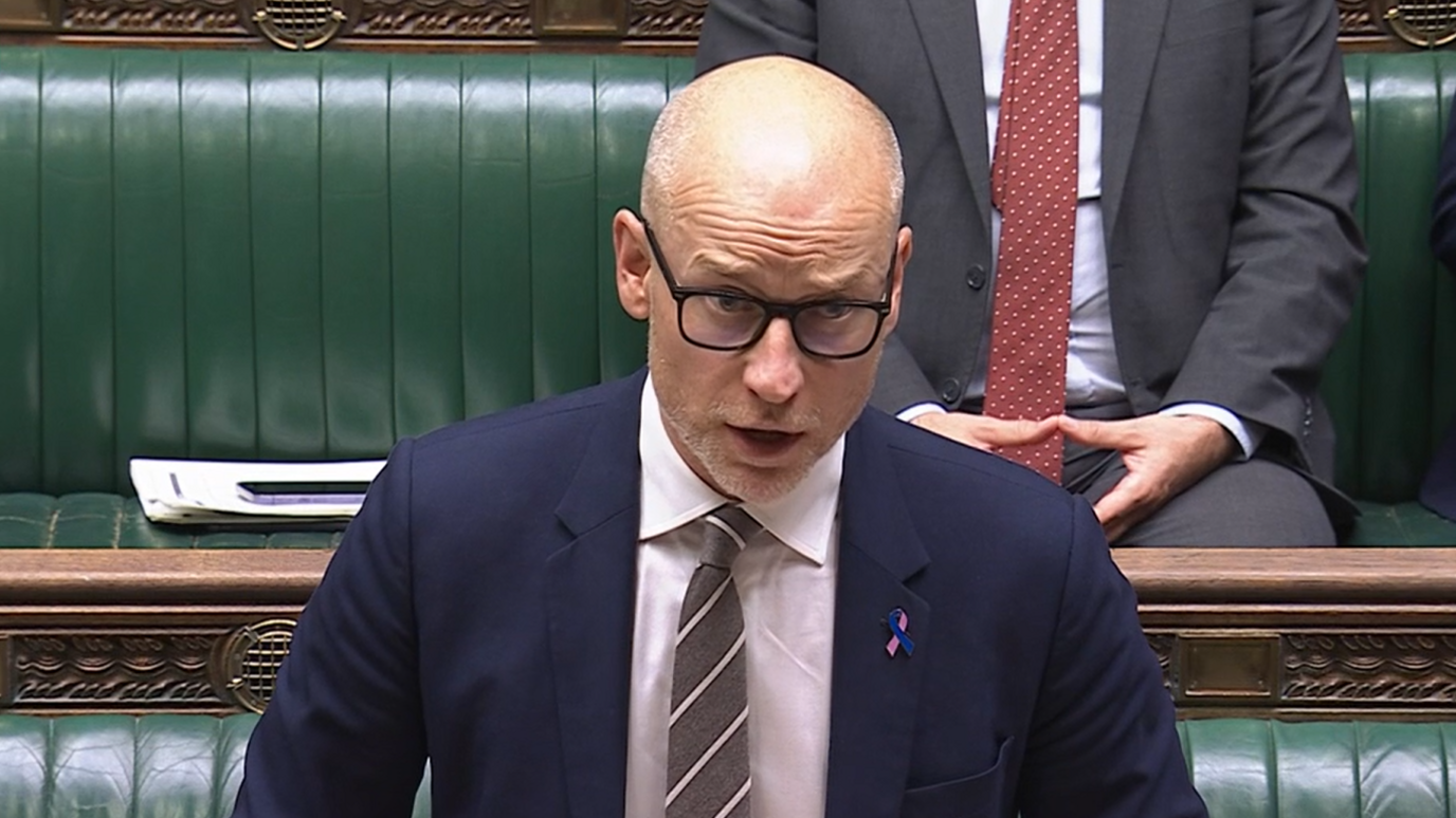 Stephen Kinnock speaks in the House of Commons. He is bald and wears glasses and a dark blue suit, white shirt and striped tie.