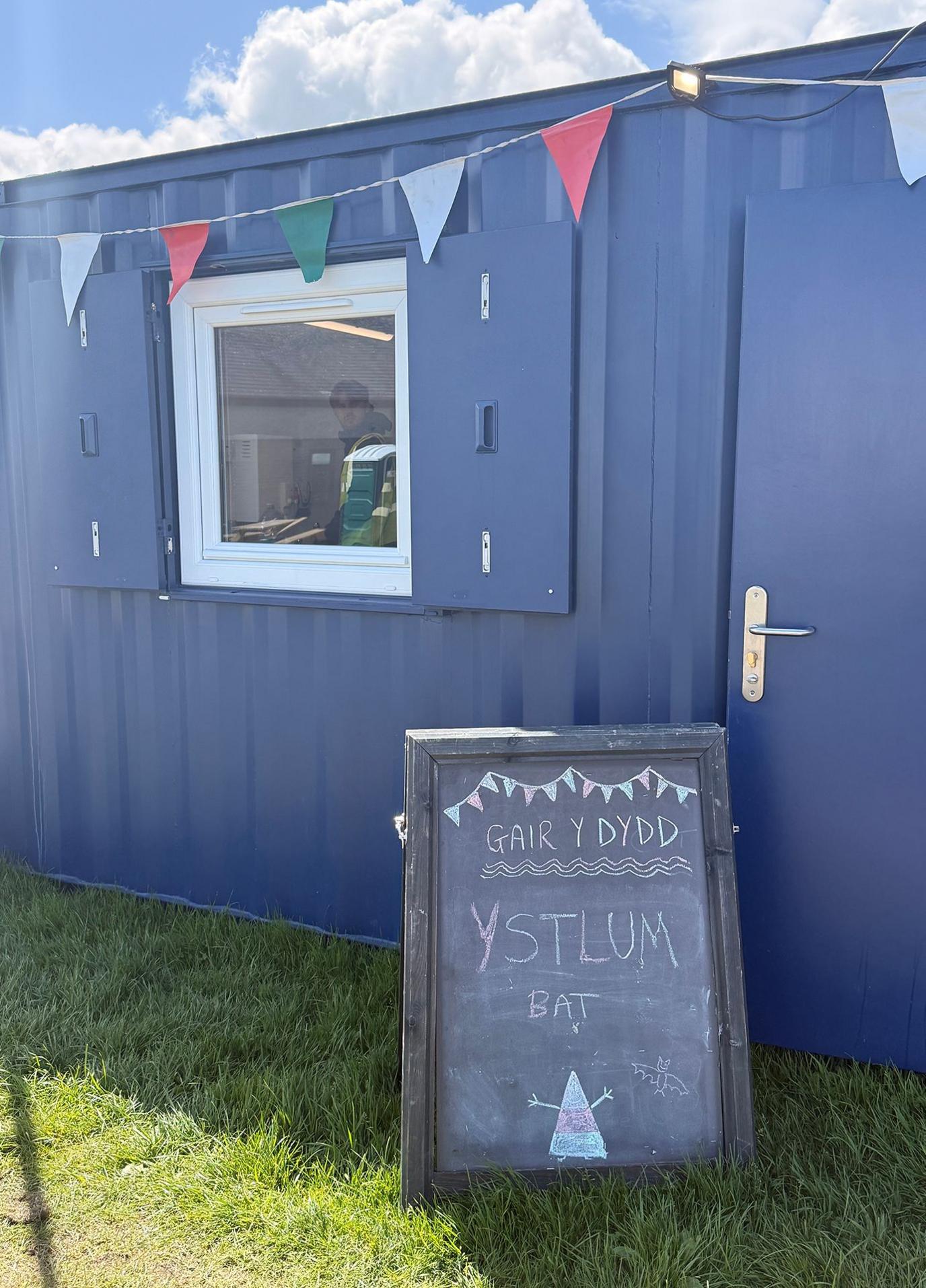 Arwydd Gair y Dydd tu allan i portacabin