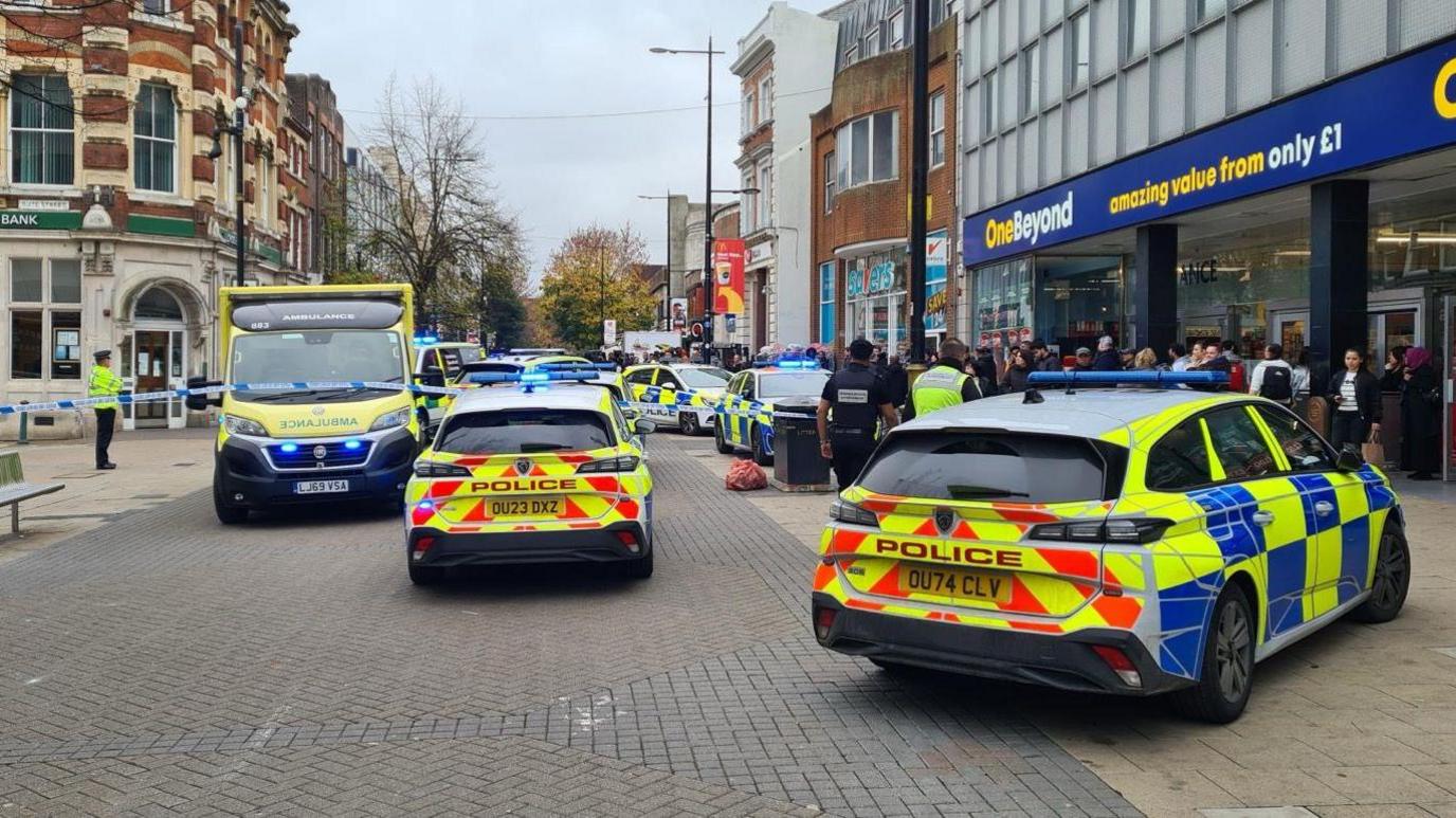 Police cars and ambulances outside shops in Luton town centre