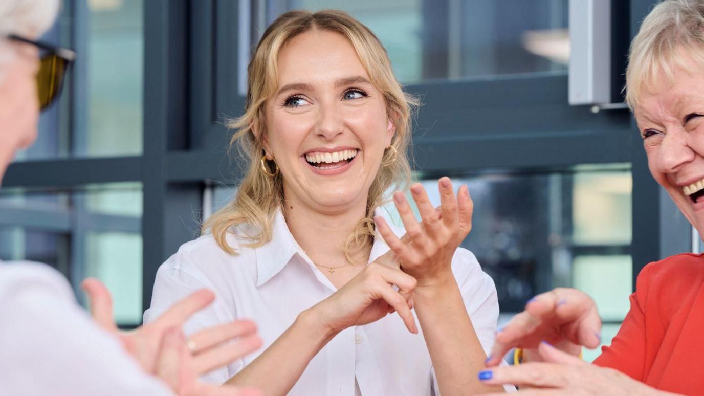 Rose Ayling-Ellis smiles as she signs with her hands