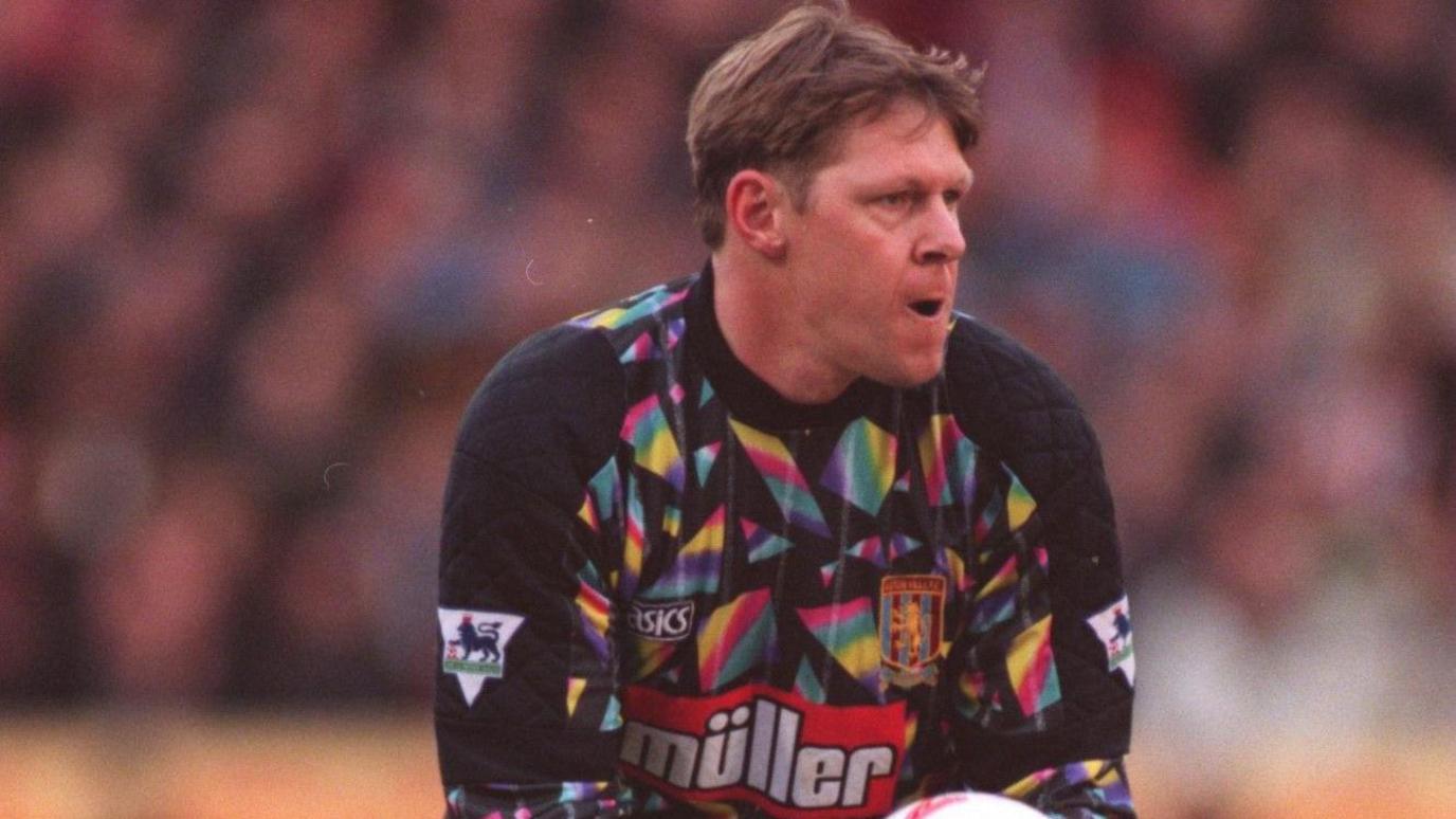 Nigel Spink wearing Aston Villa's multi-coloured goalkeeping kit, gets ready to kick the ball