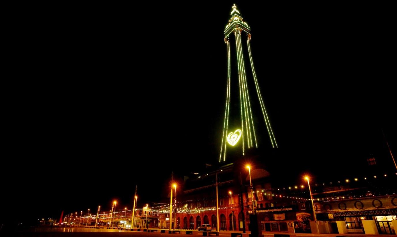 Blackpool Tower shines bright yellow, with a yellow heart lit up near the base of the landmark.