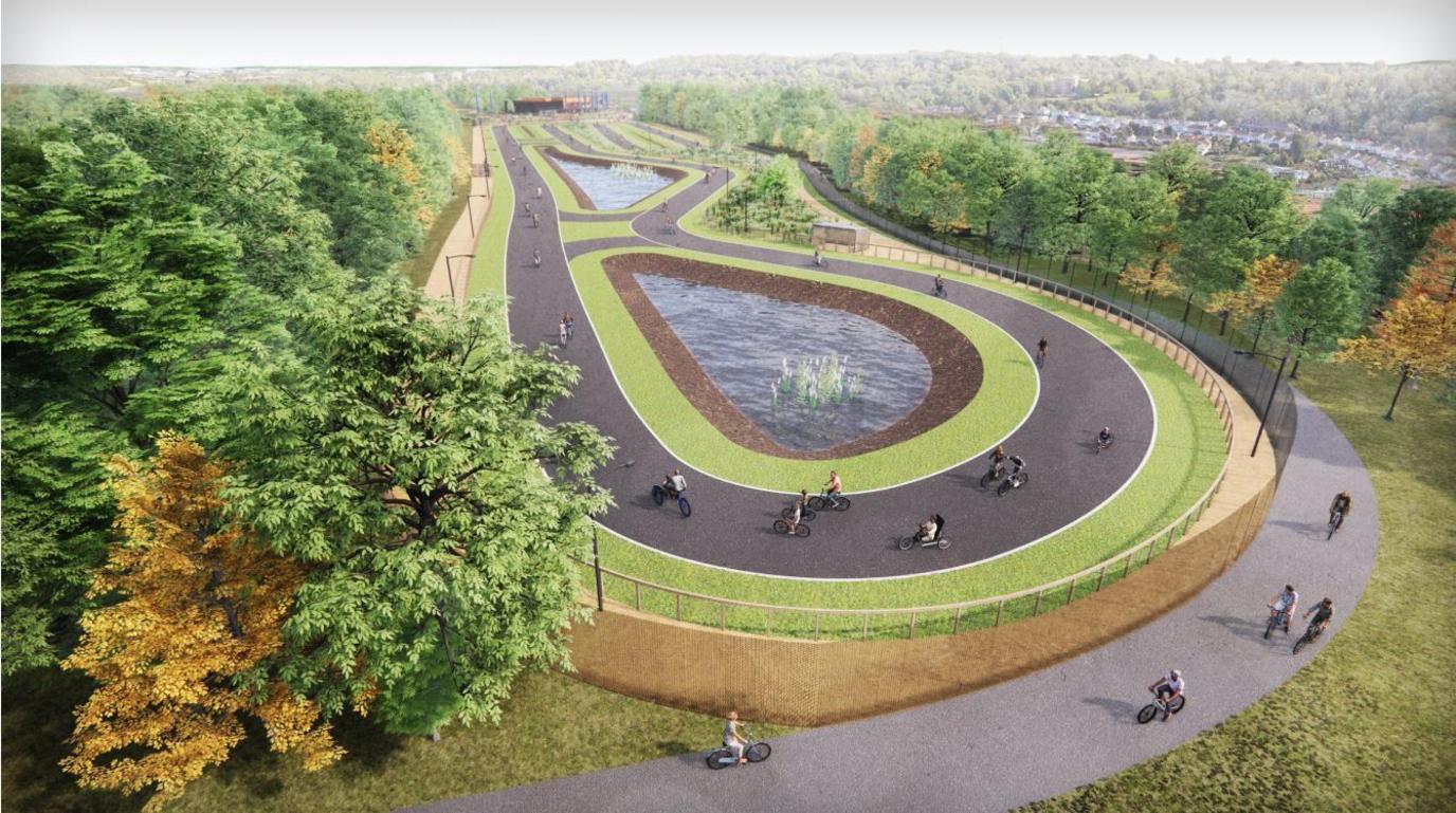 A CGI of how the Bristol Regional Cycling Hub in Lawrence Weston would look. A bird's eye view of a track surrounded by trees with ponds in the middle.