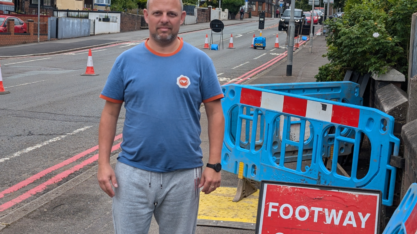 Resident David Broome stood by roadworks signs on City Road