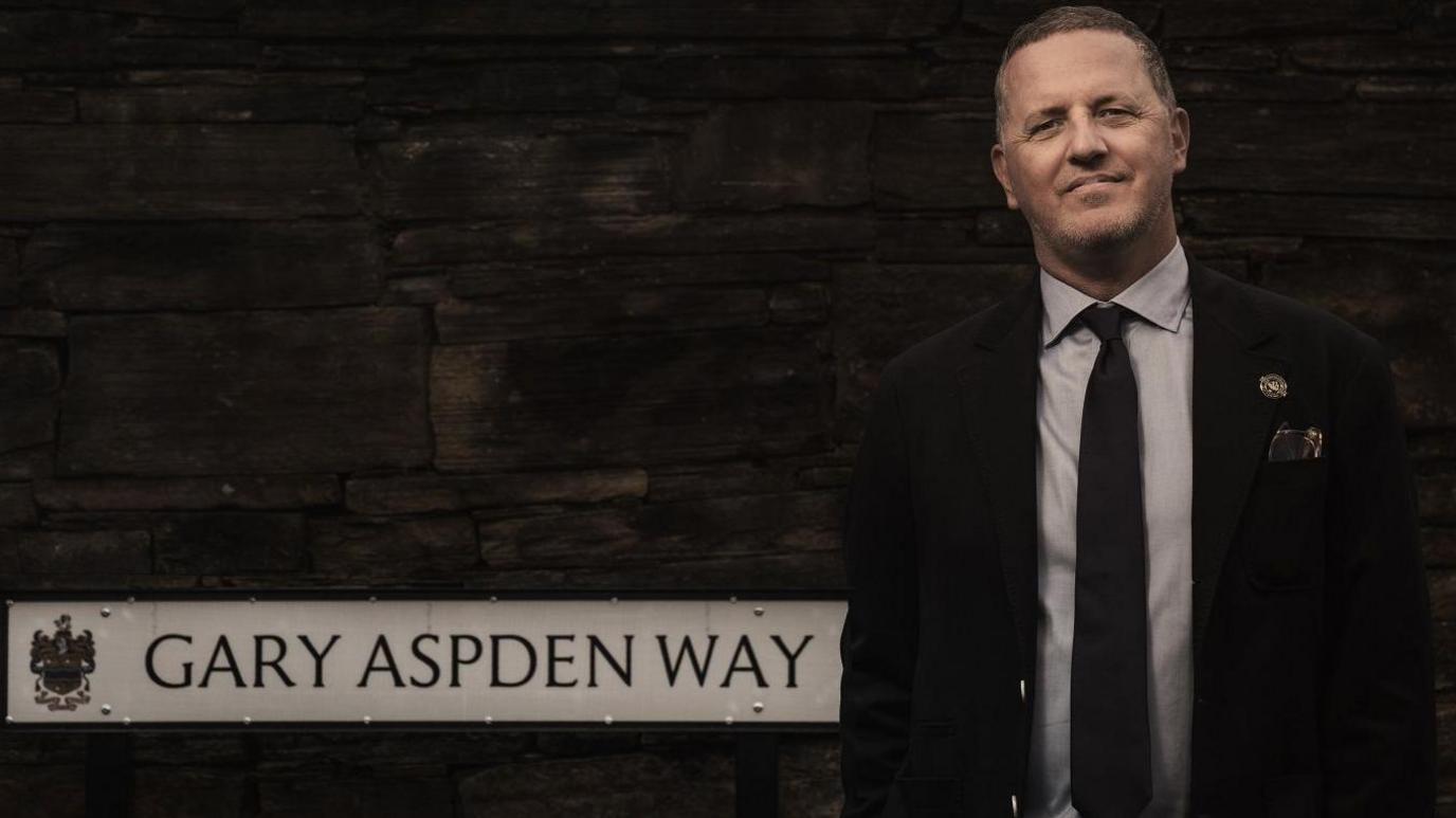 Gary Aspden standing in front of the Gary Aspden Way