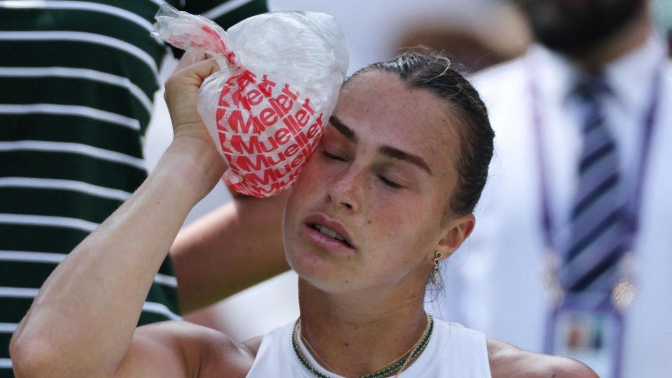 Women's world number one Aryna Sabalenka puts a bag of ice on her head