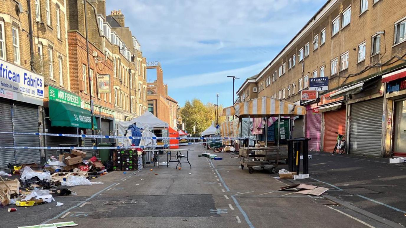 East Street in Walworth, where an empty market stall stands as well as two forensic tents, taped off by police 