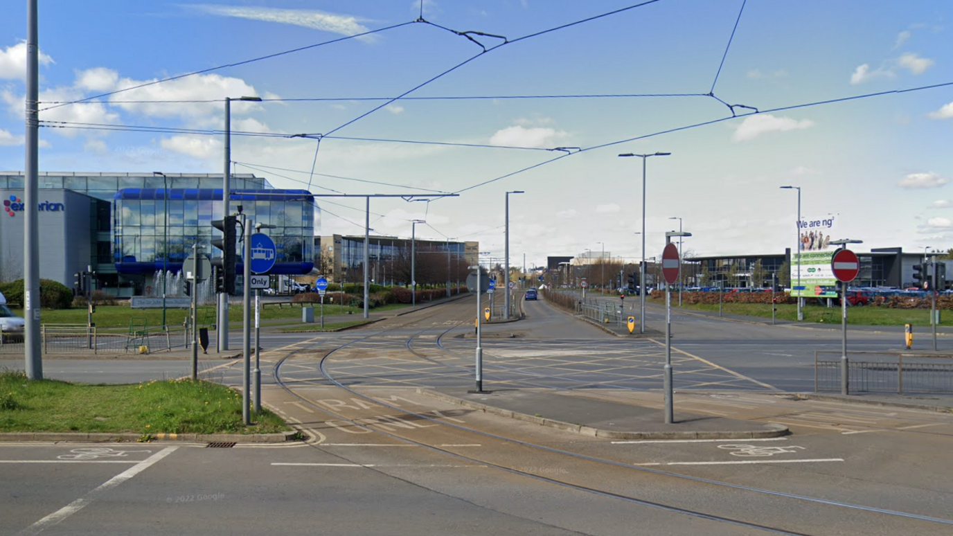 A junction at the entrance to a street with a tram line running through it