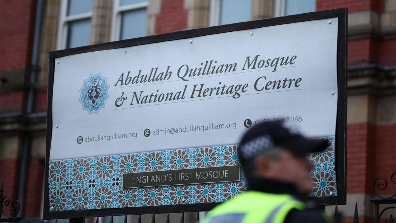 A police officer looks on during a demonstration at the Abdullah Quilliam Mosque 