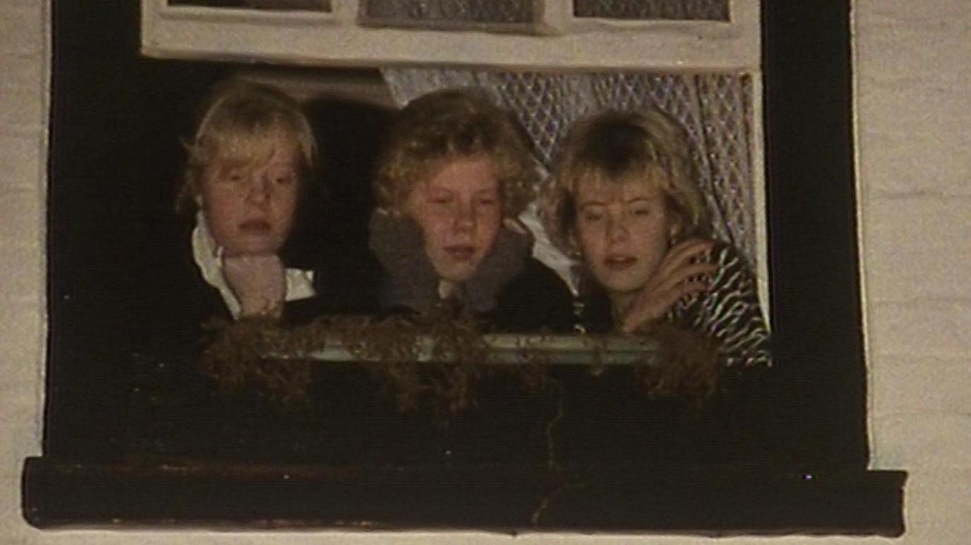 Three people look down on the tar barrels event from an upstairs window in 1986.