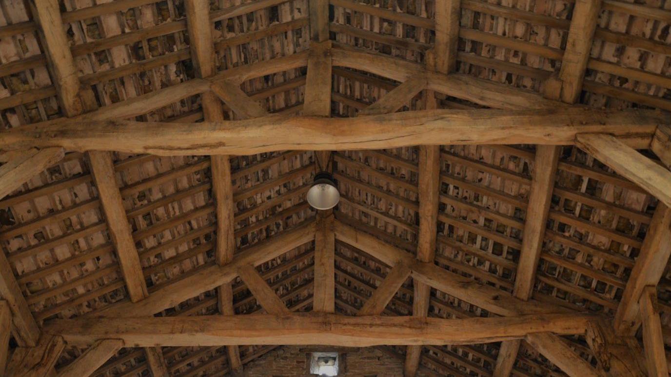 Image shows the inside of the timber-framed vaulted ceiling of the barn at Gawthorpe Hall in Padiham, Lancashire.