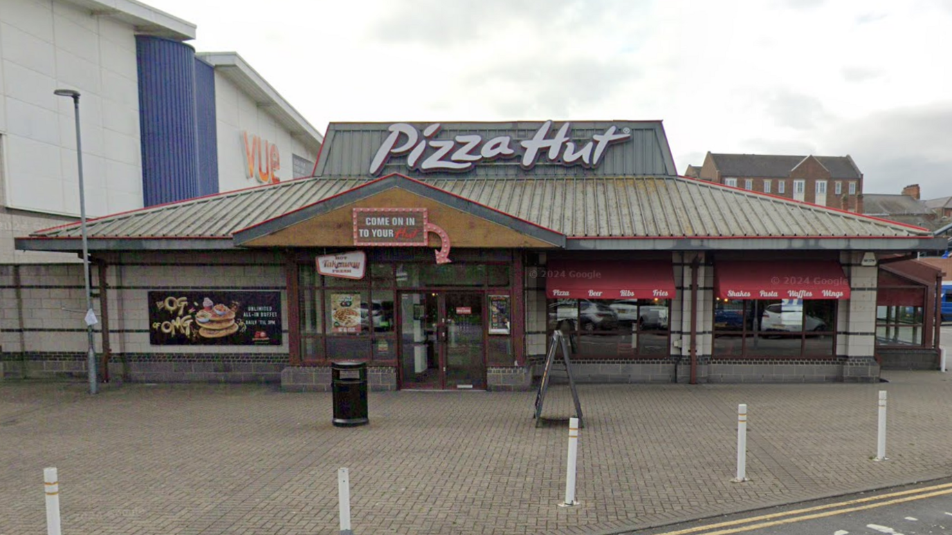 The outside of Pizza Hut in Hartlepool next to the Vue cinema. It has a large sign reading 'Pizza Hut' on the roof and a sign over the door reading 'Come on in to your hut'.