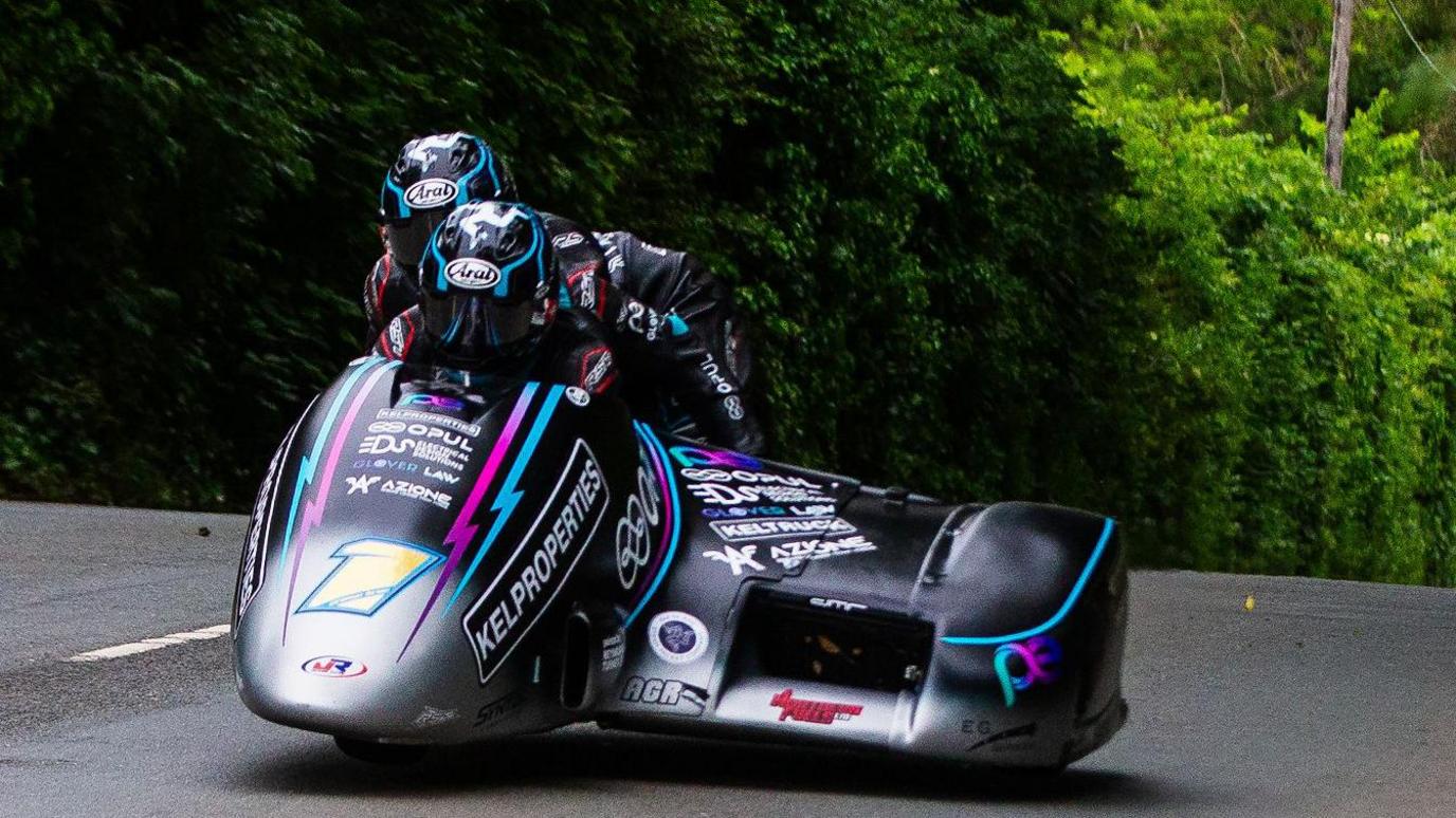 Ryan and Callum Crowe on their sidecar outfit, which has the number one on the front and is predominantly black and silver with some blue and pink.