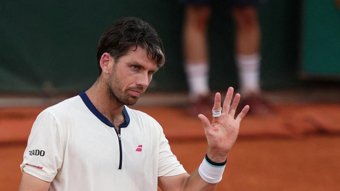 Cameron Norrie raises his hand