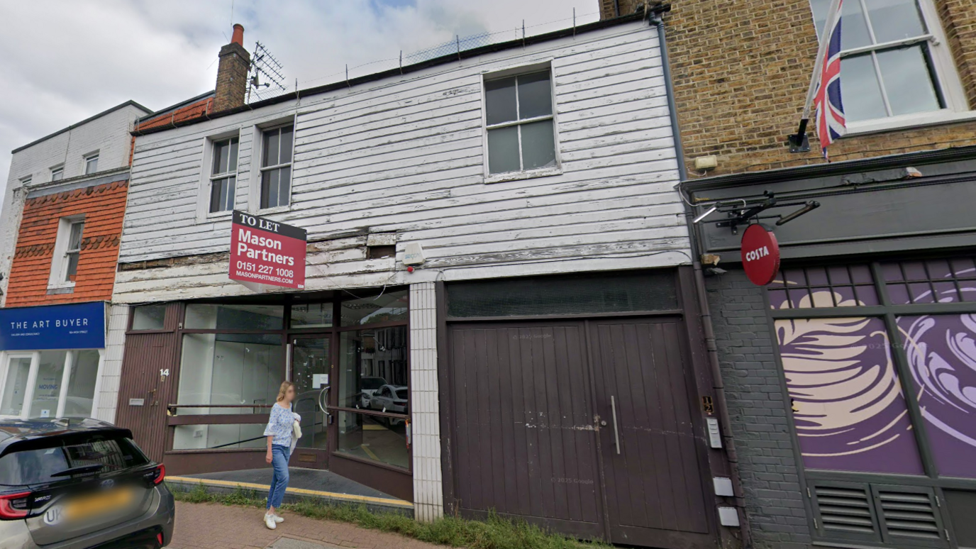 An empty shop with a 'to let' sign outside. The building looks old and dilapidated.
