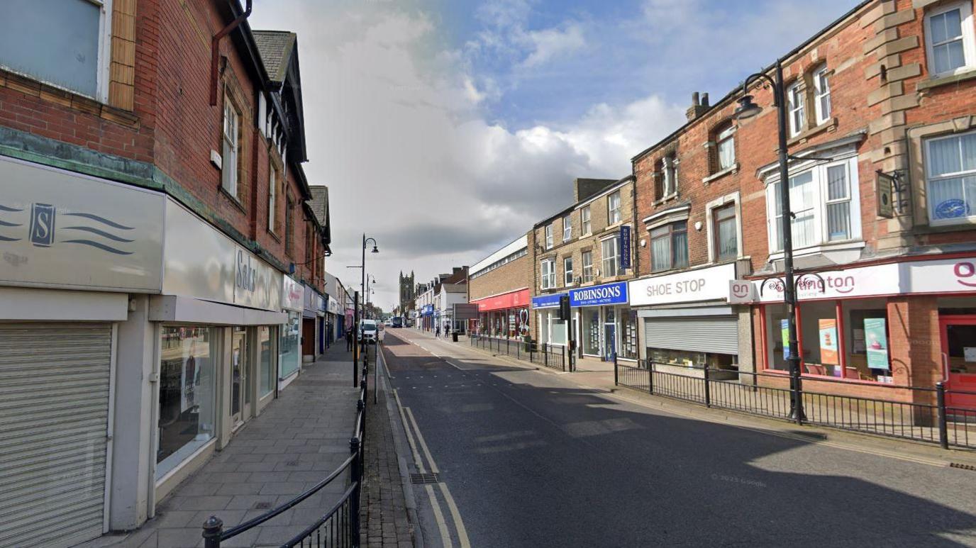 Newgate Street in Bishop Auckland. The high street is lined with plants.