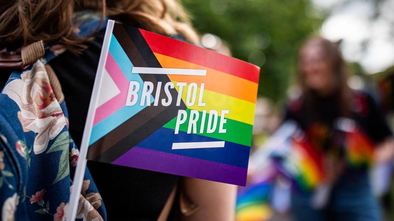 An image of a paper pride flag bearing the words Bristol Pride