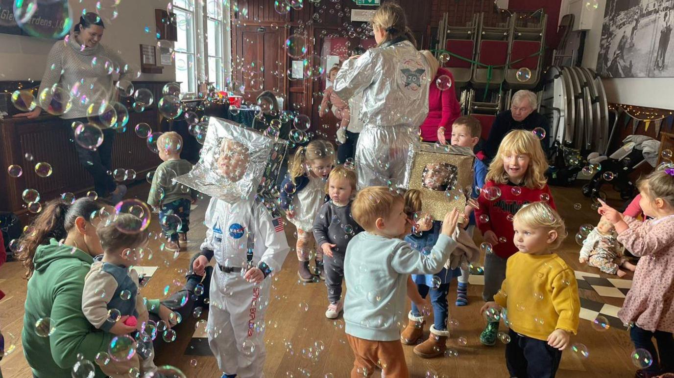 Singing Jo and Co session with children playing with bubbles