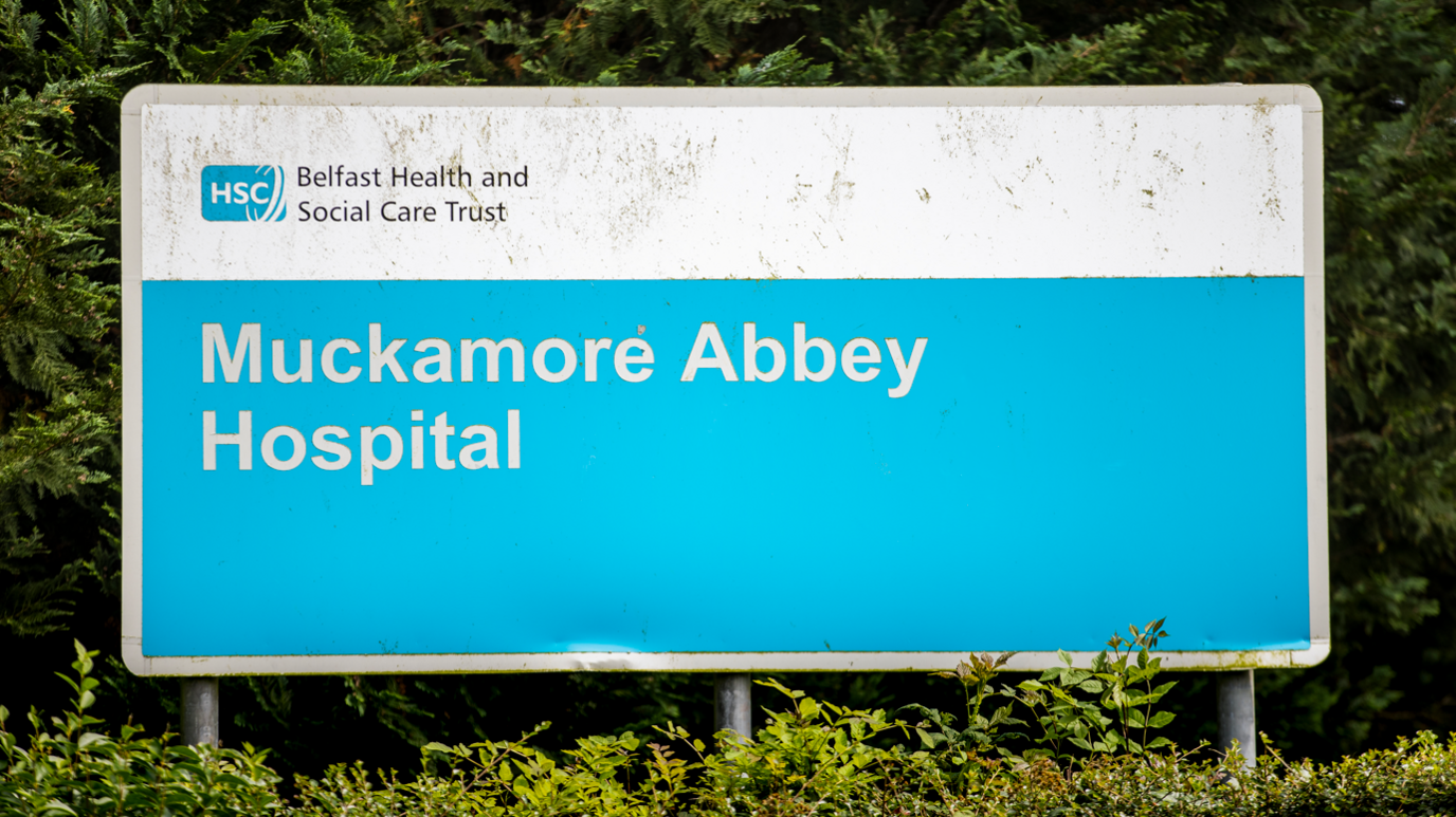 A blue and white sign reading "Muckamore Abbey Hospital".