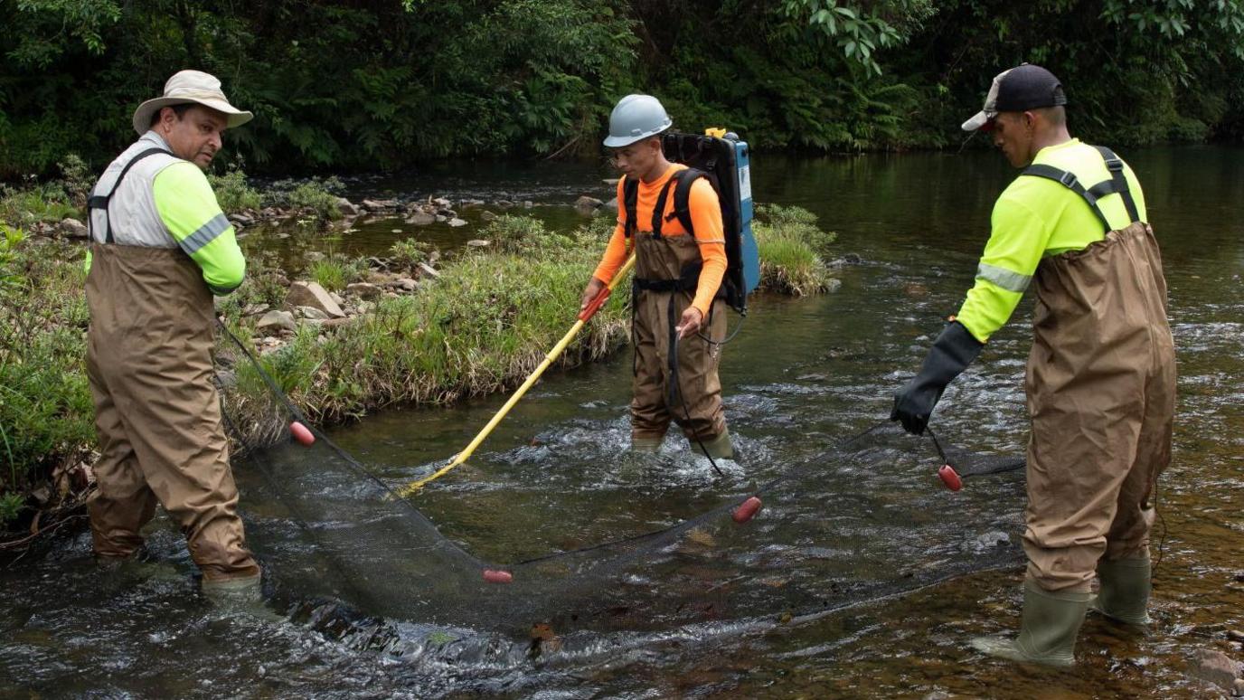 Samuel Valdés, left, testing water quality near the mine