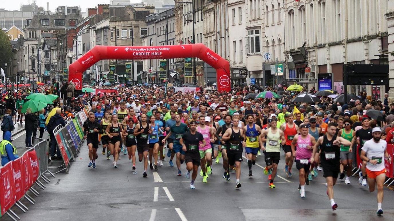 Hundreds of runners go under the starting banner outside Cardiff Castle on Sunday 6 October 2024