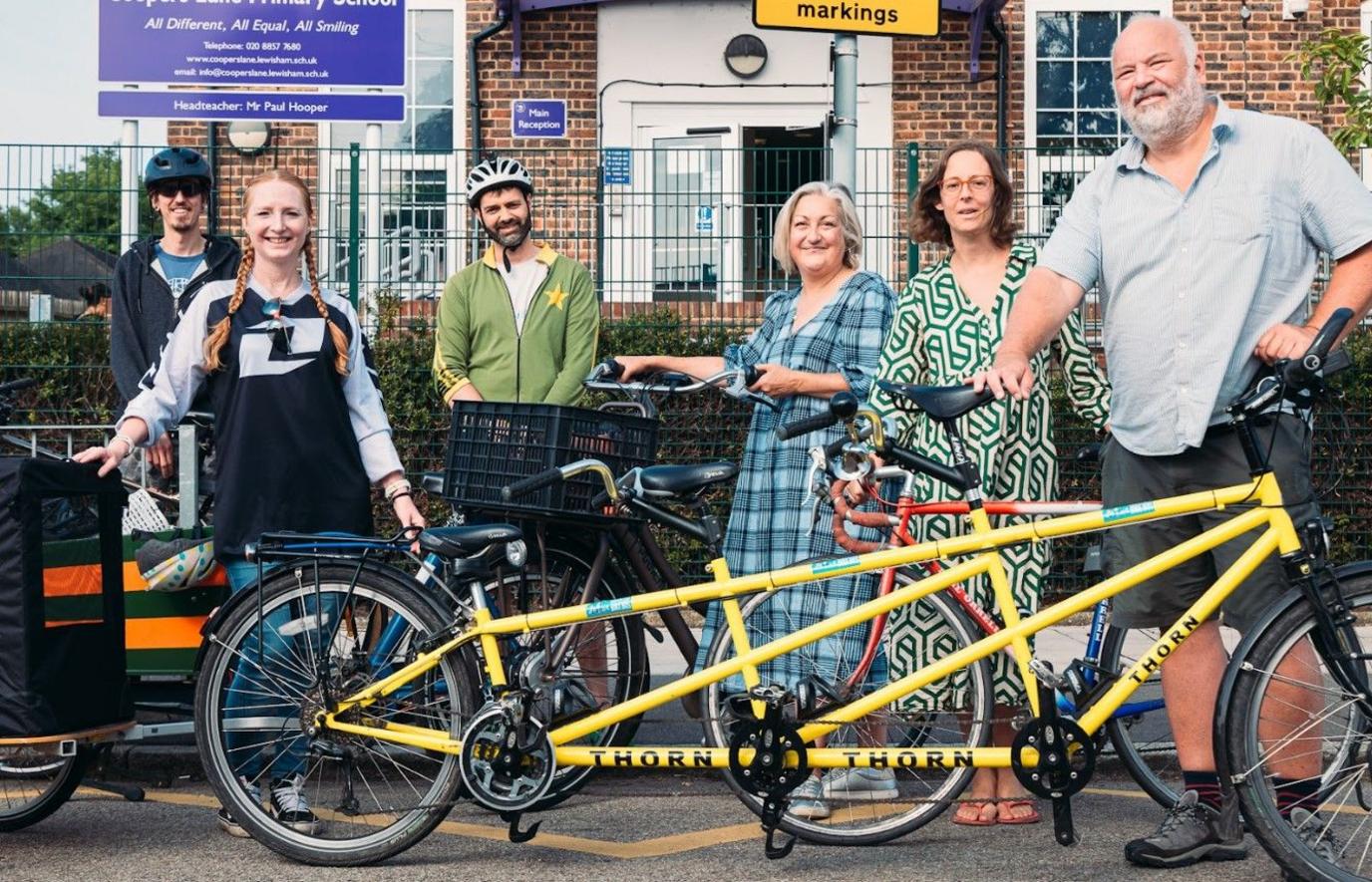 A group of parents standing in front of their bikes