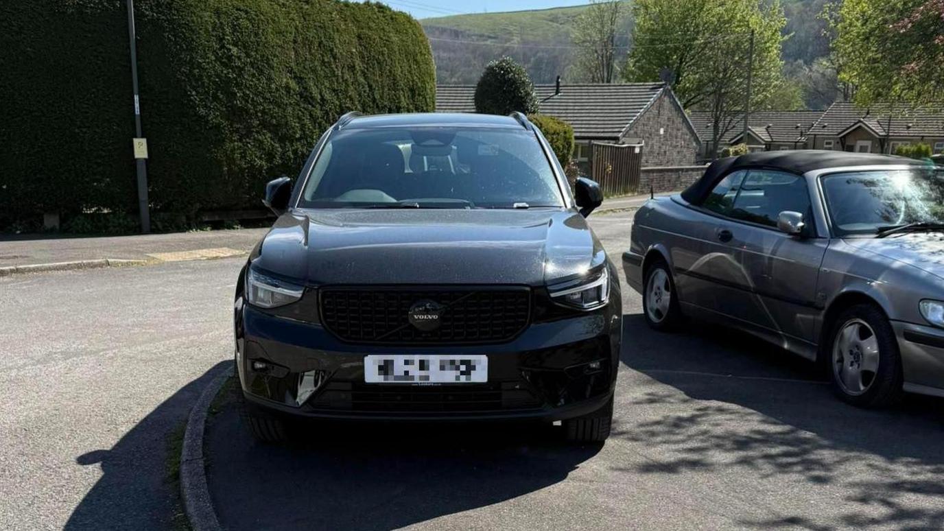Two cars parked on a pavement