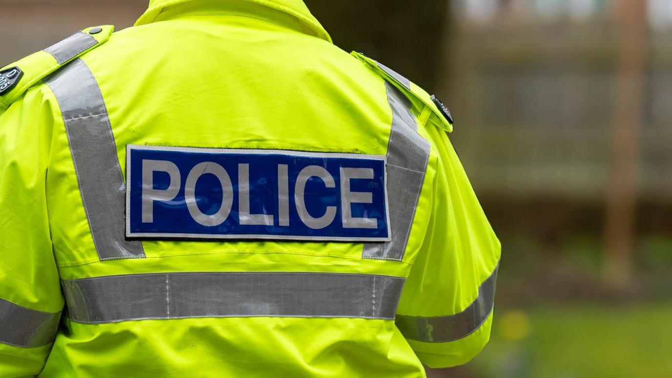 Stock image of a policeman walking away from a home