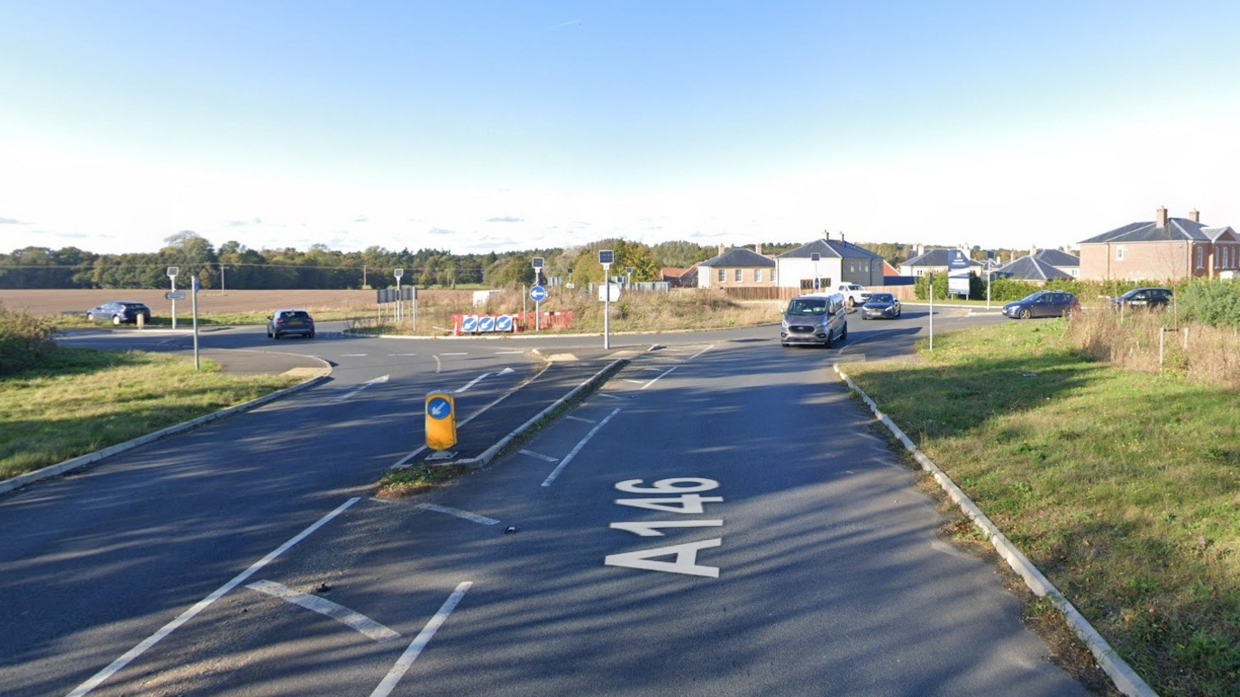 A Google Maps screengrab of the A146 Loddon roundabout. You can see the road going up to the roundabout. There are two cars going towards the first exit and two cars coming towards the camera. It's a bright day, and the blue sky is in the background. 