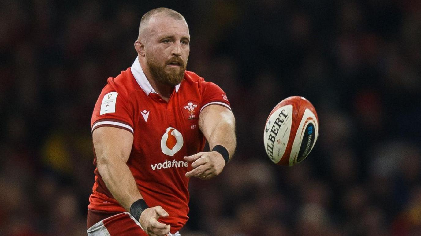 Prop Dillon Lewis passes the ball for Wales in the 2024 Six Nations