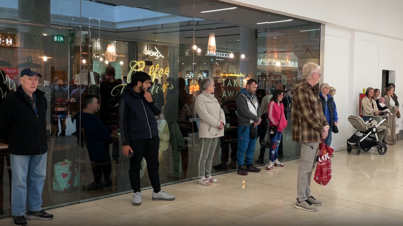 Shoppers in the Derbion Shopping Centre marking the two minute silence in memory of those who died in World War Two