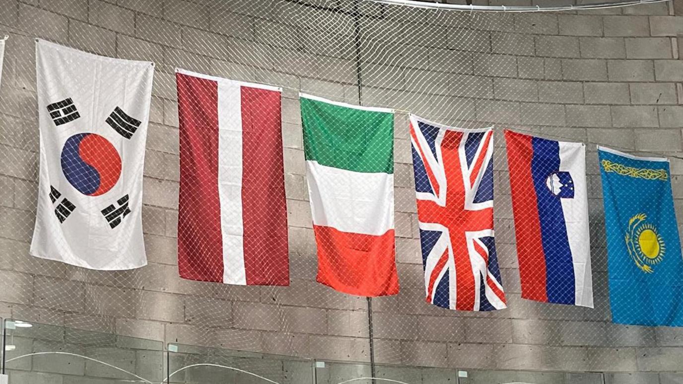 A series of flags of competing nations across the Dumfries Ice Bowl wall