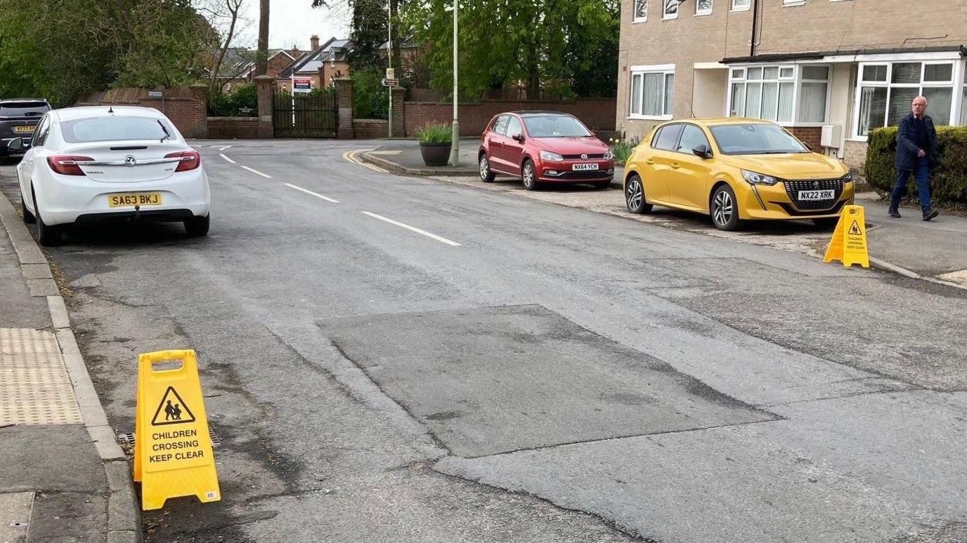 Two mobile Children Crossing - Keep Clear warning signs near kerbs at Middleton Lane.