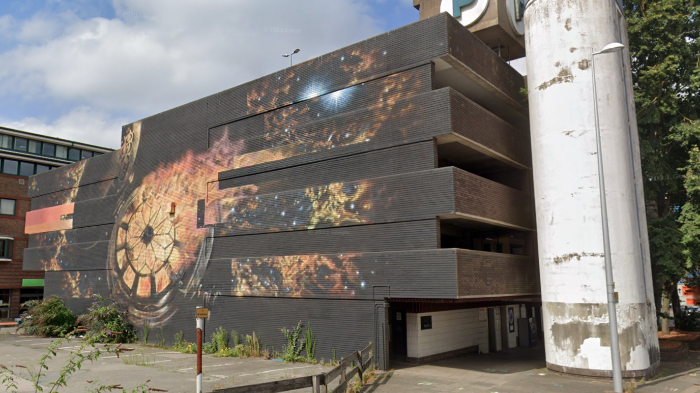 The mural of a burning watch in space, on the side of the car park in Coventry