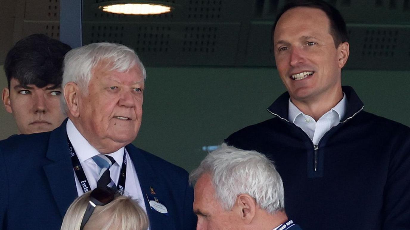 Black Knight's Ryan Caswell (right) watches an Exeter game alongside Tony Rowe