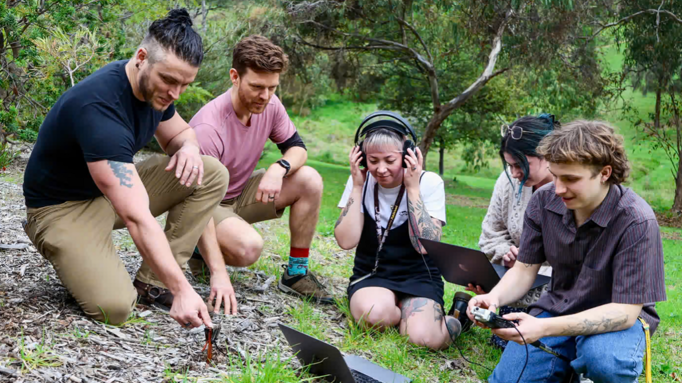 5 members of the team test the sound under the soil using microphones under the ground
