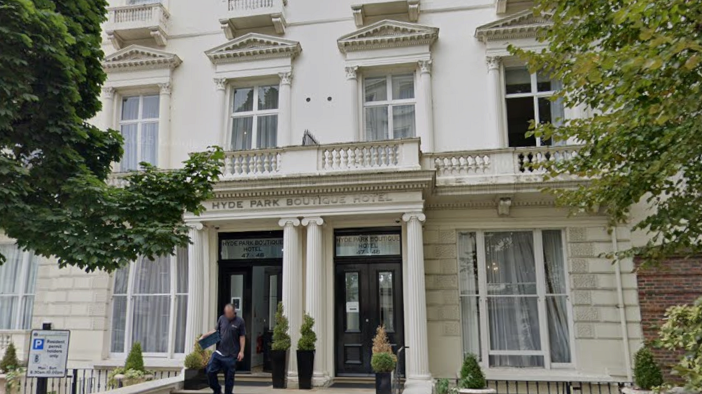 A white terraced building with tall windows and columns at the entrance to the Hyde Park Boutique Hotel.