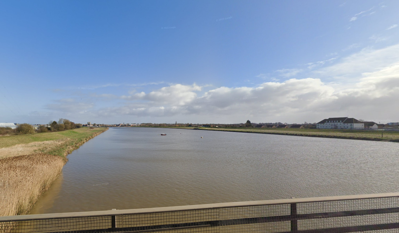 Wide shot of the river Great Ouse near King's Lynn, showing expanse of water and buildings in the distance